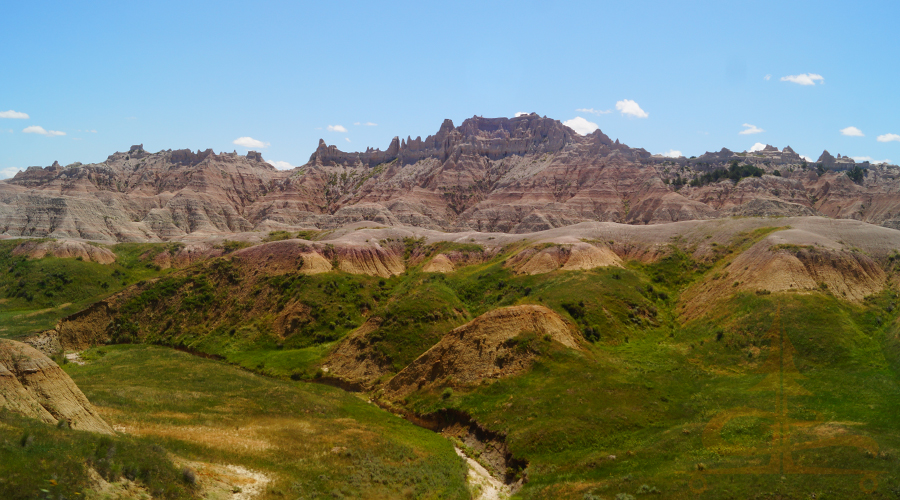 green prairie reaching rugged badlands