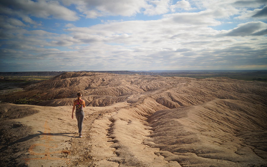 hiker walking among the badlands