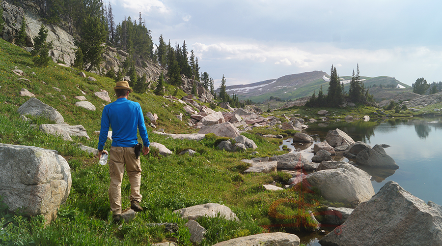 hiker among granite boulders lake side 