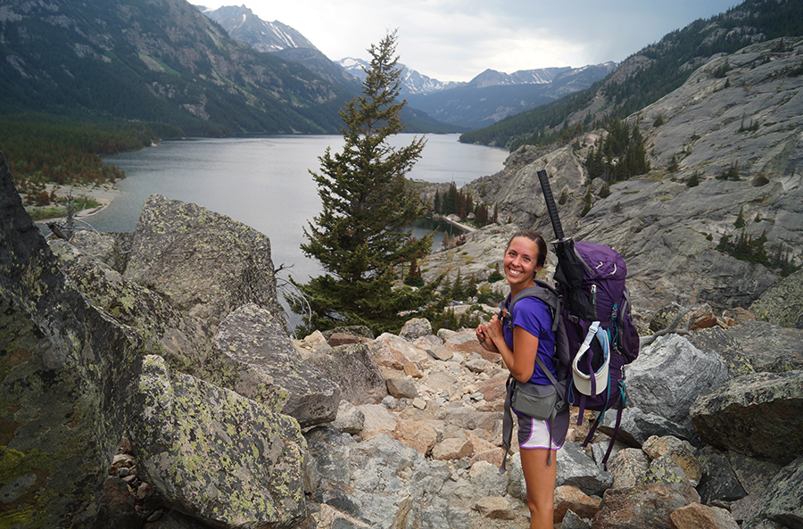 hiker above mystic lake with granite mountains in background