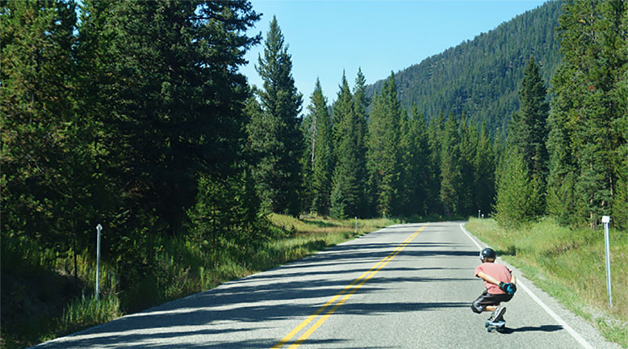 longboarding down a straightaway in hyalite canyon