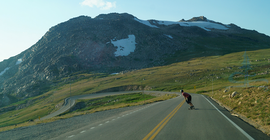 longboarding around a curve on beartooth highway