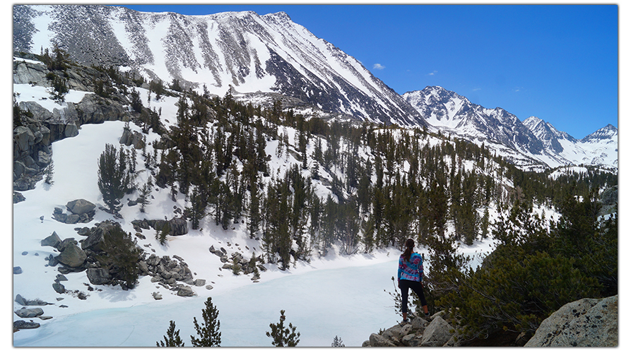 overlooking a snow covered lake on little lakes valley trail