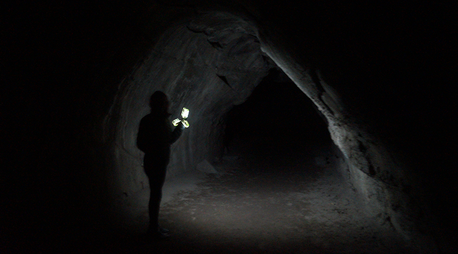 hiking through subway cave with a flashlight