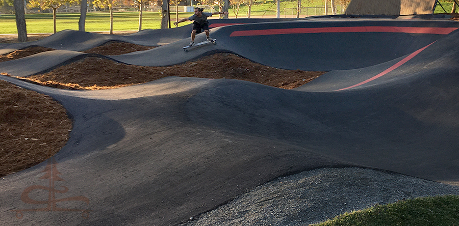 surfing the cement on a longboard at the temecula pump track