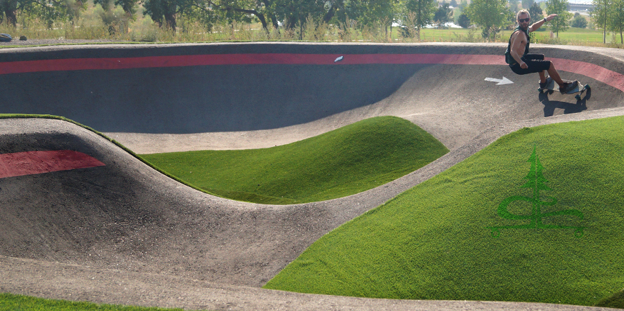 surfing the cement while longboarding in a pump track