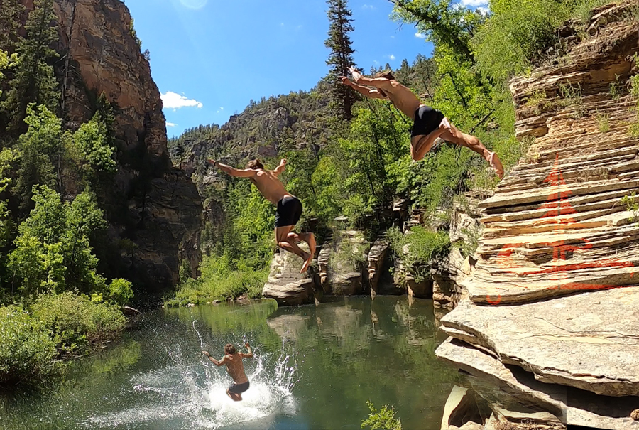 jumping off a rock wall into the swimming hole