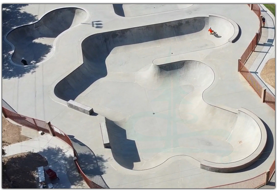 longboarder in large vert bowl at rotary skatepark