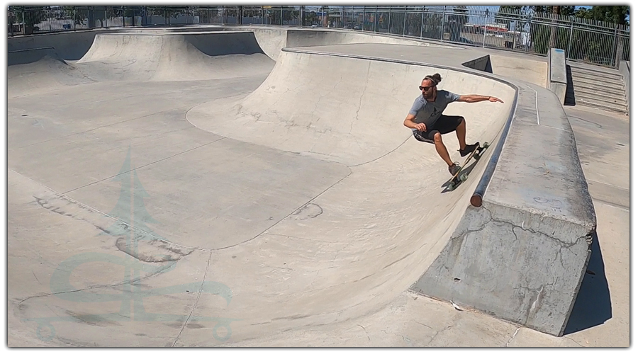 cement surfing on a longboard in a skatepark